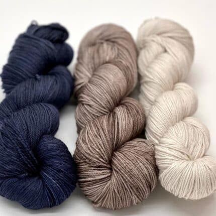 Three skeins of yarn, blue, grey and light silver gray.