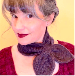 A light-skinned woman with a hand knit scarf.