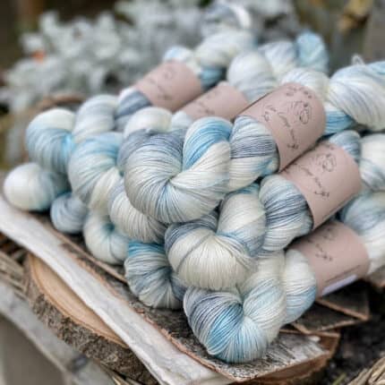 A pile of skeins of variegated yarn in cream and blue.