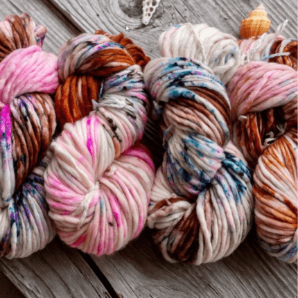 Four skeins of multi-colored speckled yarn.
