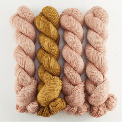 Four skeins of pink and gold yarn.