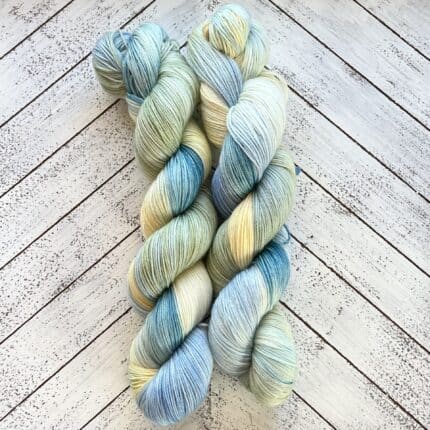 Two skeins of yarn in blue, green and yellow.
