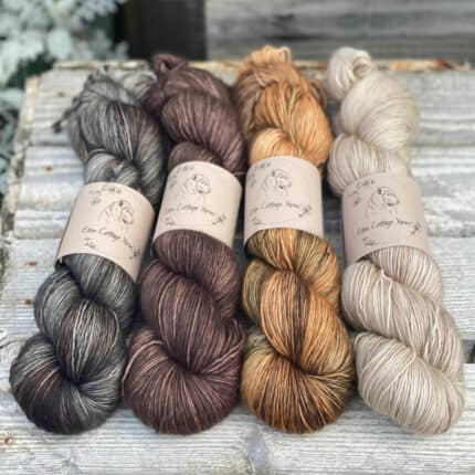 Four shades of yarn in shades of brown, beige and grey.