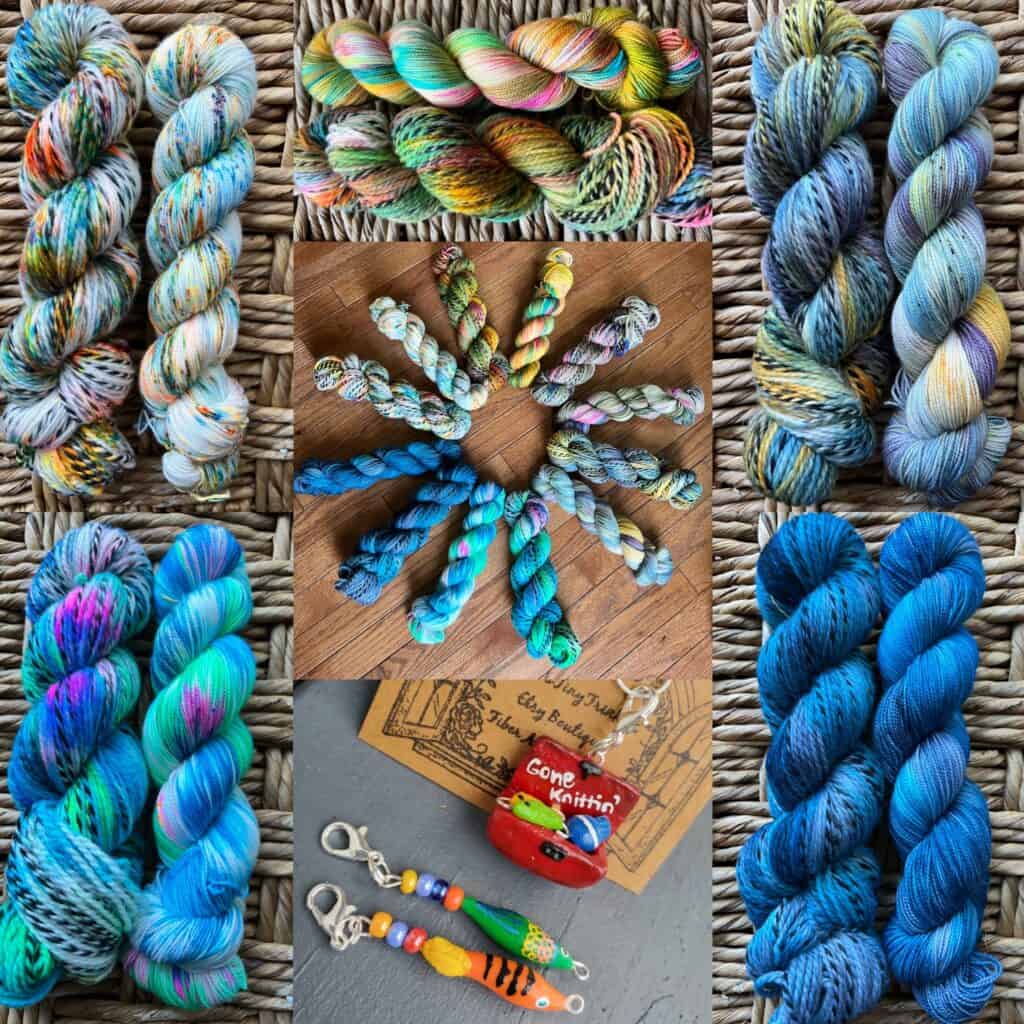 Skeins of yarn on blacked striped wool in various hues of blue, green and orange. A bait and tackle box charm that reads Gone knittin'.