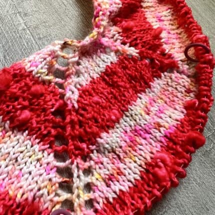 The start of a knit tee shirt in a bright red slub yarn and brightly speckled darling dahlia colorway.