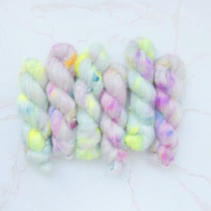 A pastel sage mohair yarn speckled with pops of neon yellow and pink and deep green