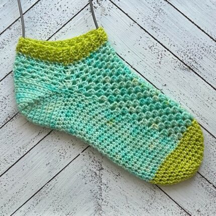 A crochet sock in blue and green.