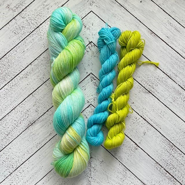 Skein of yarn in aqua blue and light green.