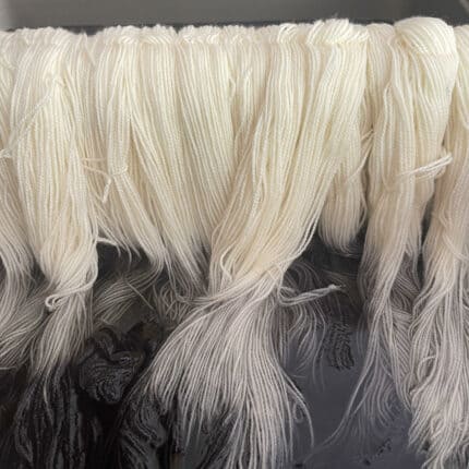 White yarn being dyed black.