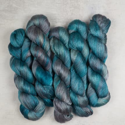 Skeins of hand-dyed silky blue and gray yarn.