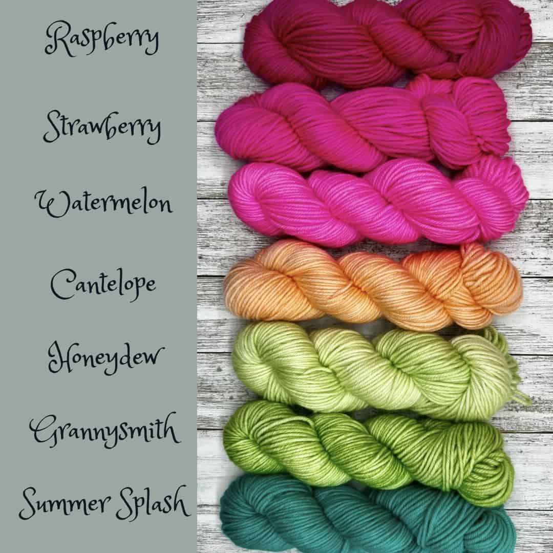 Seven skeins of yarn from dark pink to light pink, peach in the middle, light green and aqua.
