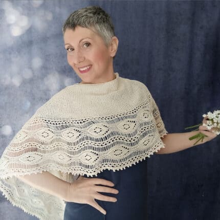 A white woman wearing a shawl. The shawl has a half donut shape and a lacy border.