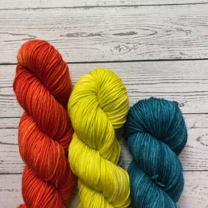 Three staggered skeins of yarn in orange, bright yellow and spruce green.