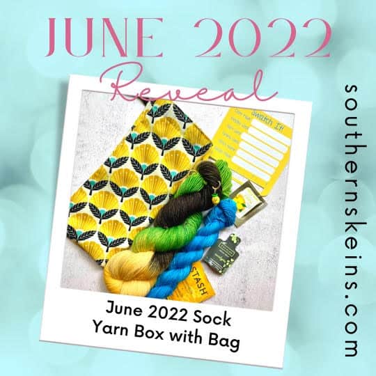 A full skein of green, black and yellow yarn and a blue mini skein next to yellow floral fabric. The text June 2022 Reveal, June 2022 Sock Yarn Box with Bag.
