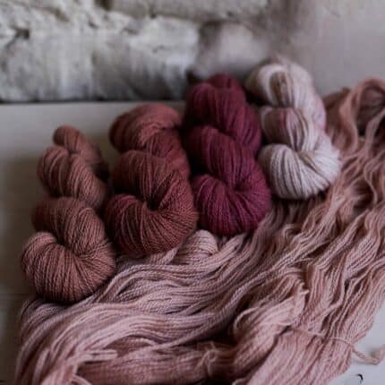 Skeins of yarn in burgundy and warm dark and light pink tones as inspiration for Warm&Cosy bundle.