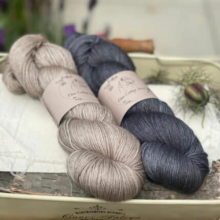 Two skeins of yarn, one light brown and one dark grey.
