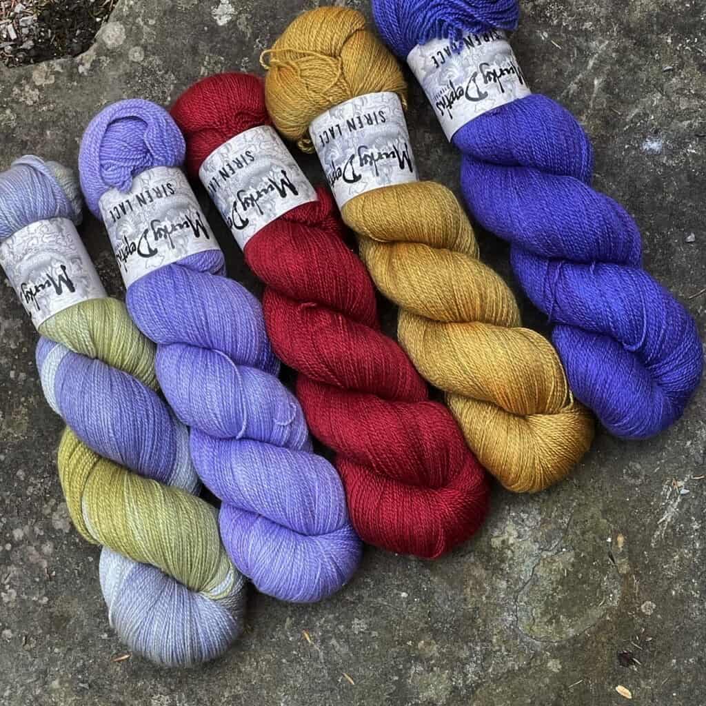 Skeins of yarn in blue, red and gold.