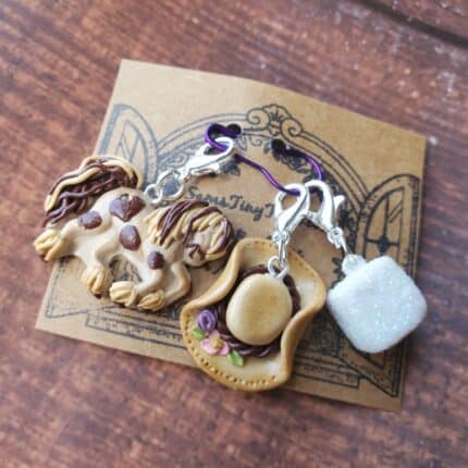 A knitting jewelry set with a brown spotted horse, a tan cowgirl hat and a sugar cube.