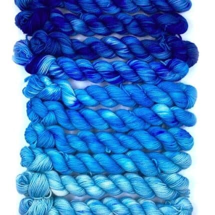 A set of gradient yarn in light to dark blue.