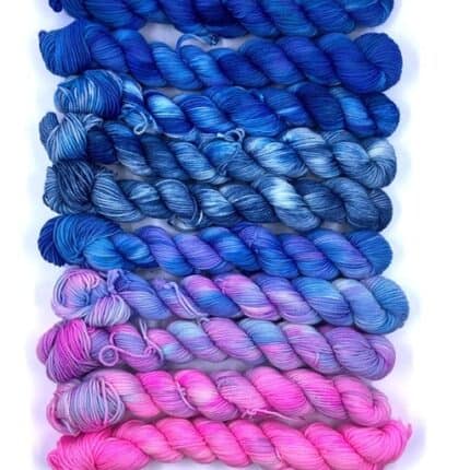 A set of gradient yarn in blue to purple to pink.