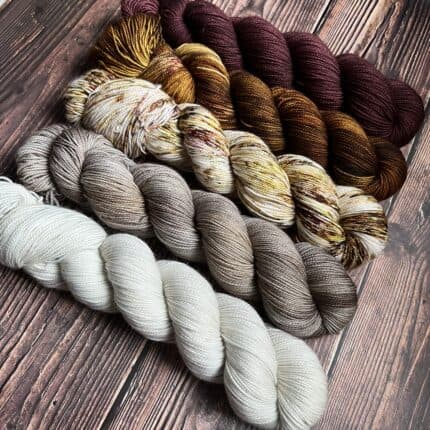 White, grey, speckled brown and gold, deep leather browns and mahogany skeins of yarn.