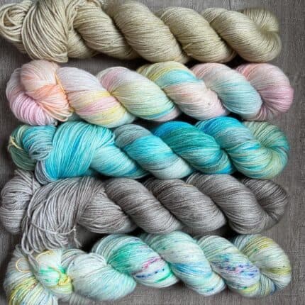 An ocean city themed set including sand beach tonal, a boardwalk grey, carousel mint speckled, taffy pink and variegated blues and ocean blue variegated skein with hints of green.