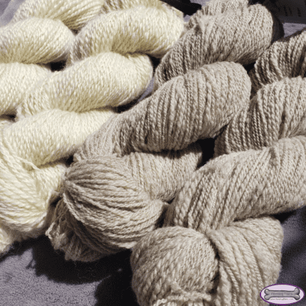 Two ivory and two grey skeins of yarn.