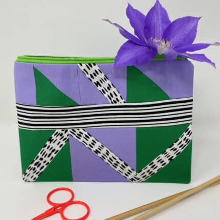 A rectangular patchwork project bag in lilac, green and black and white fabric.