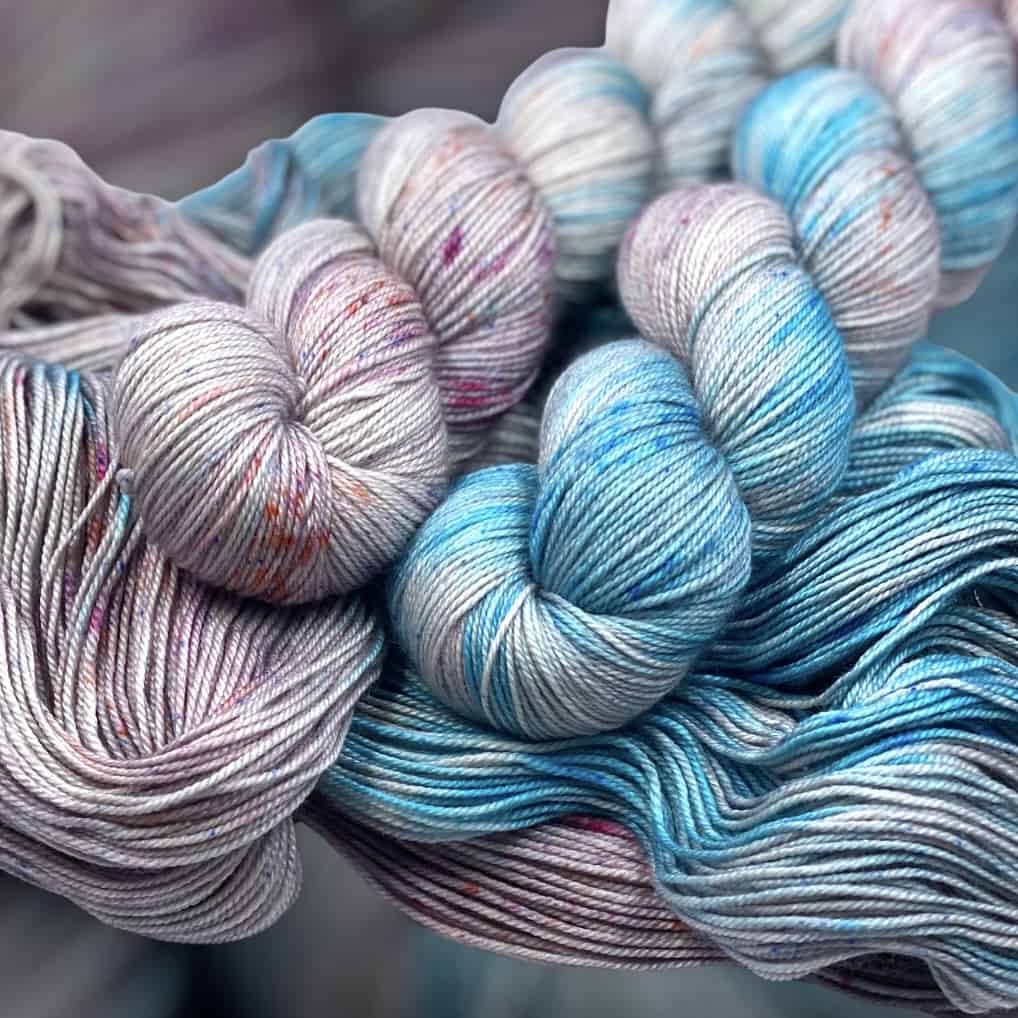 Two skeins of lavender and blue yarn.