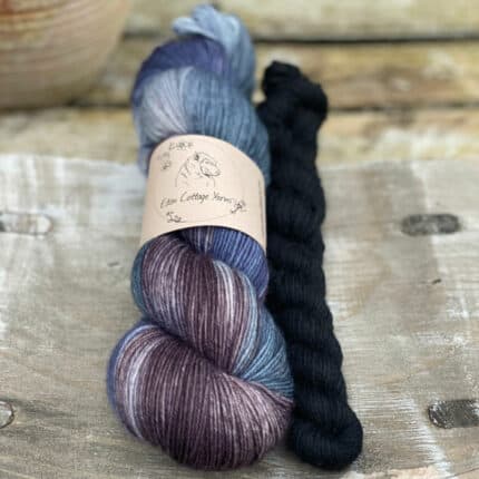 One variegated blue and purple skein with a black mini skein.