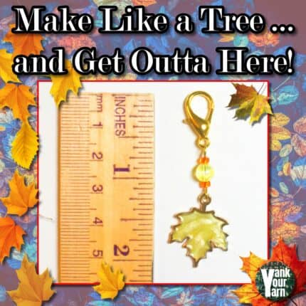 A gold lobster clasp stitch marker with a yellow maple leaf charm and yellow and orange accent beads next to a ruler indicating 2 inches, surrounded by illustrations of orange and yellow leaves and the text Make like a tree and get outta here!