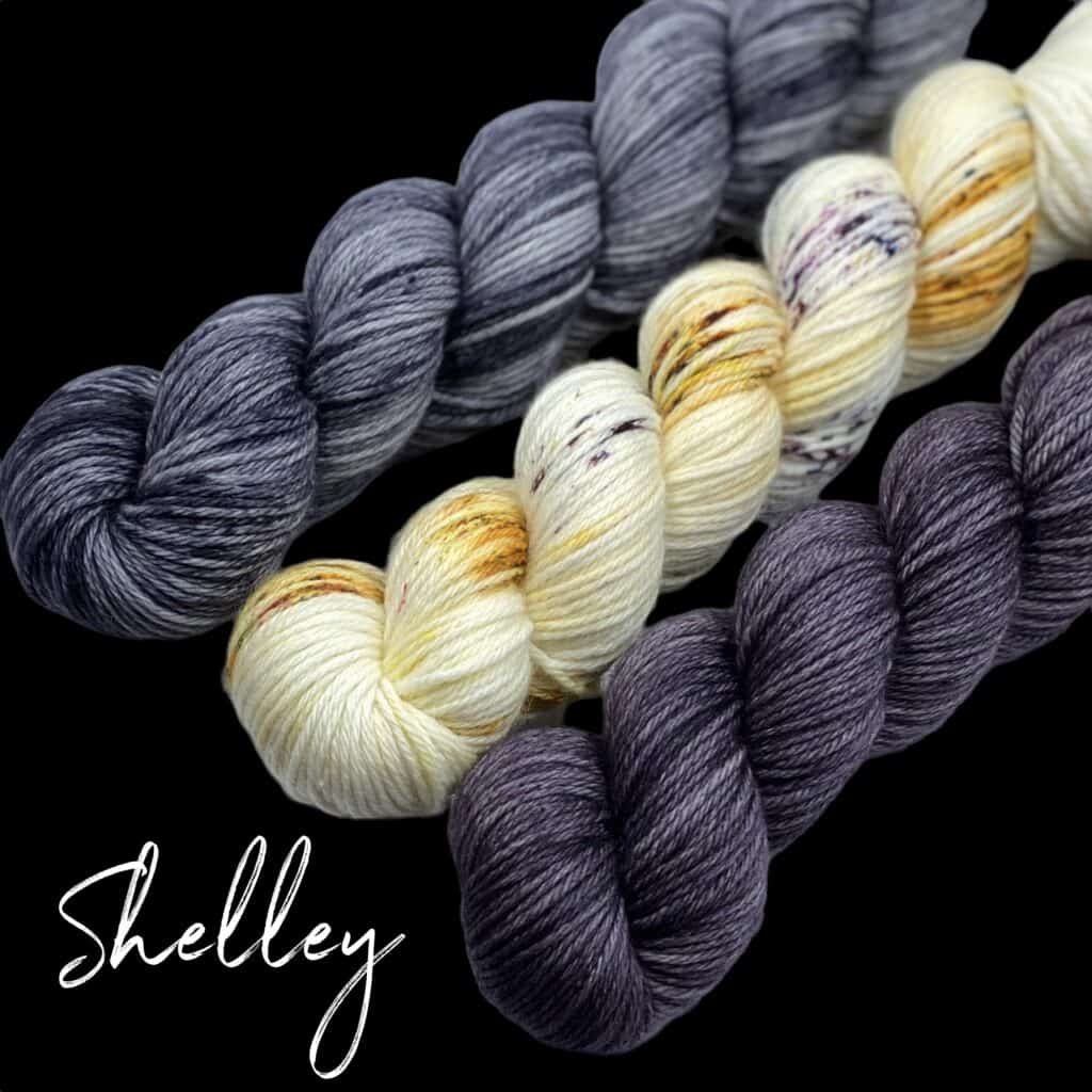 Three skeins of gray and cream yarn with the word Shelley written in cursive in white on a black background.