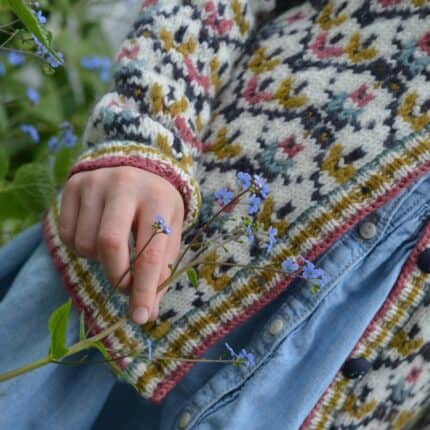 Close up view of cuff and button band of child's cardigan sweater.