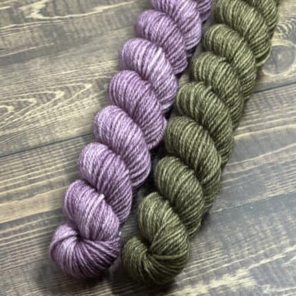 A skein of lavender yarn and a skein of moss green yarn.