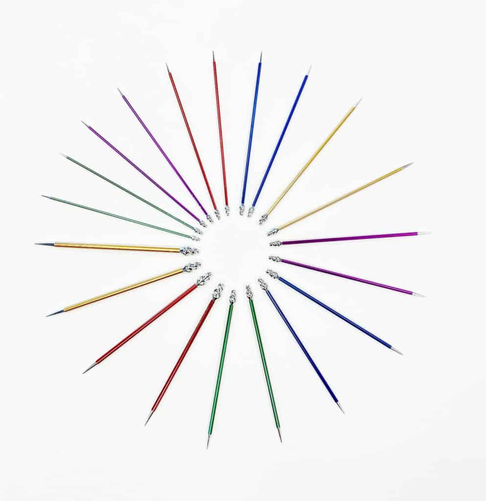 Multicolored knitting needles arranged in a circle.
