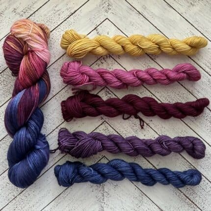 Large skein of red/yellow yarn, 5 small skeins of yarn in various colors.