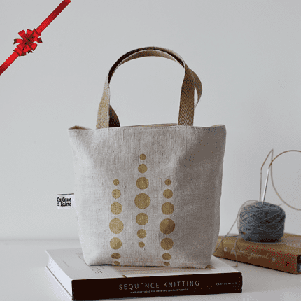 A beige bag with a gold circles print.
