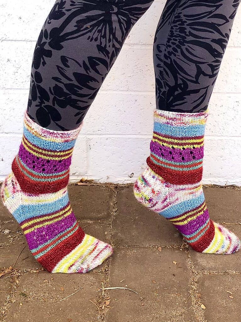 A pair of handknit socks made from a variety of mini skeins in different colors and stitch patterns.