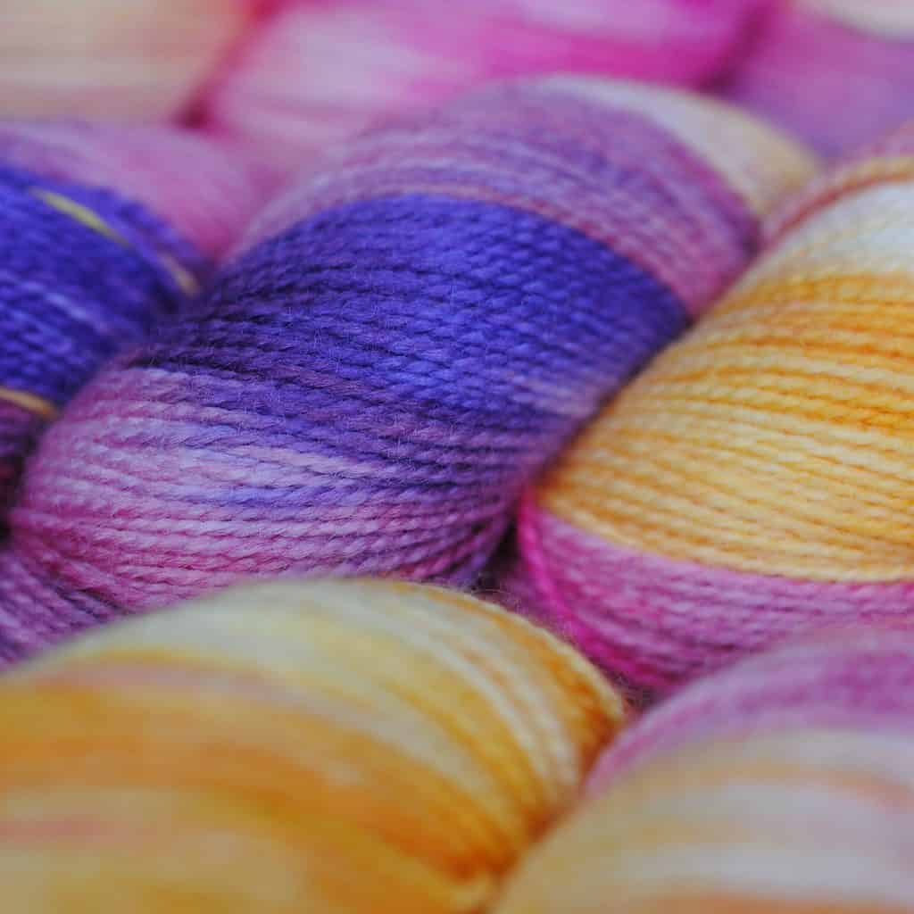 A skein of yarn in purple, pink and yellow.