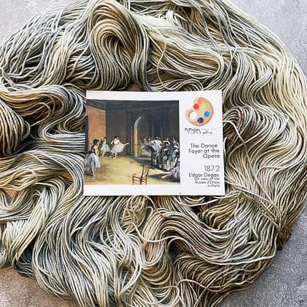 A skein of soft blue and brown yarn and art card.