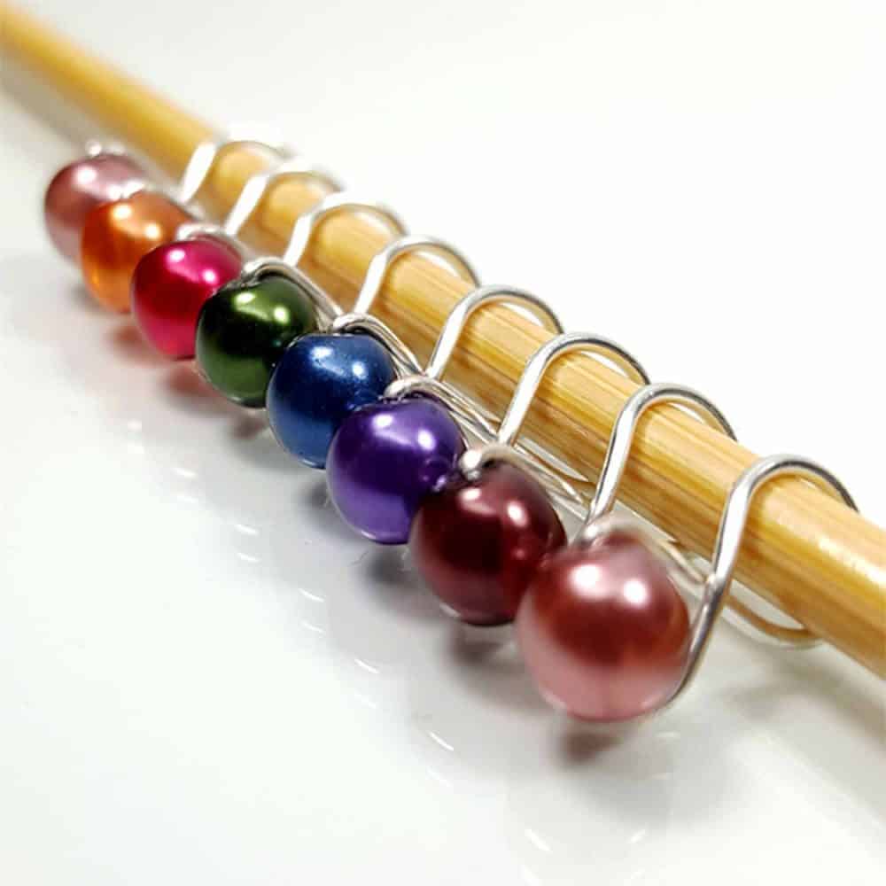 Silver stitch markers with beads in rainbow colors.