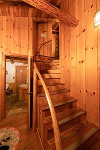 A winding staircase in paneled wood.