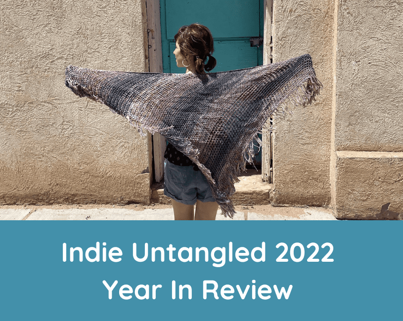 A woman holding up a blue and purple shawl, and the words Indie Untangled 2022 Year In Review.