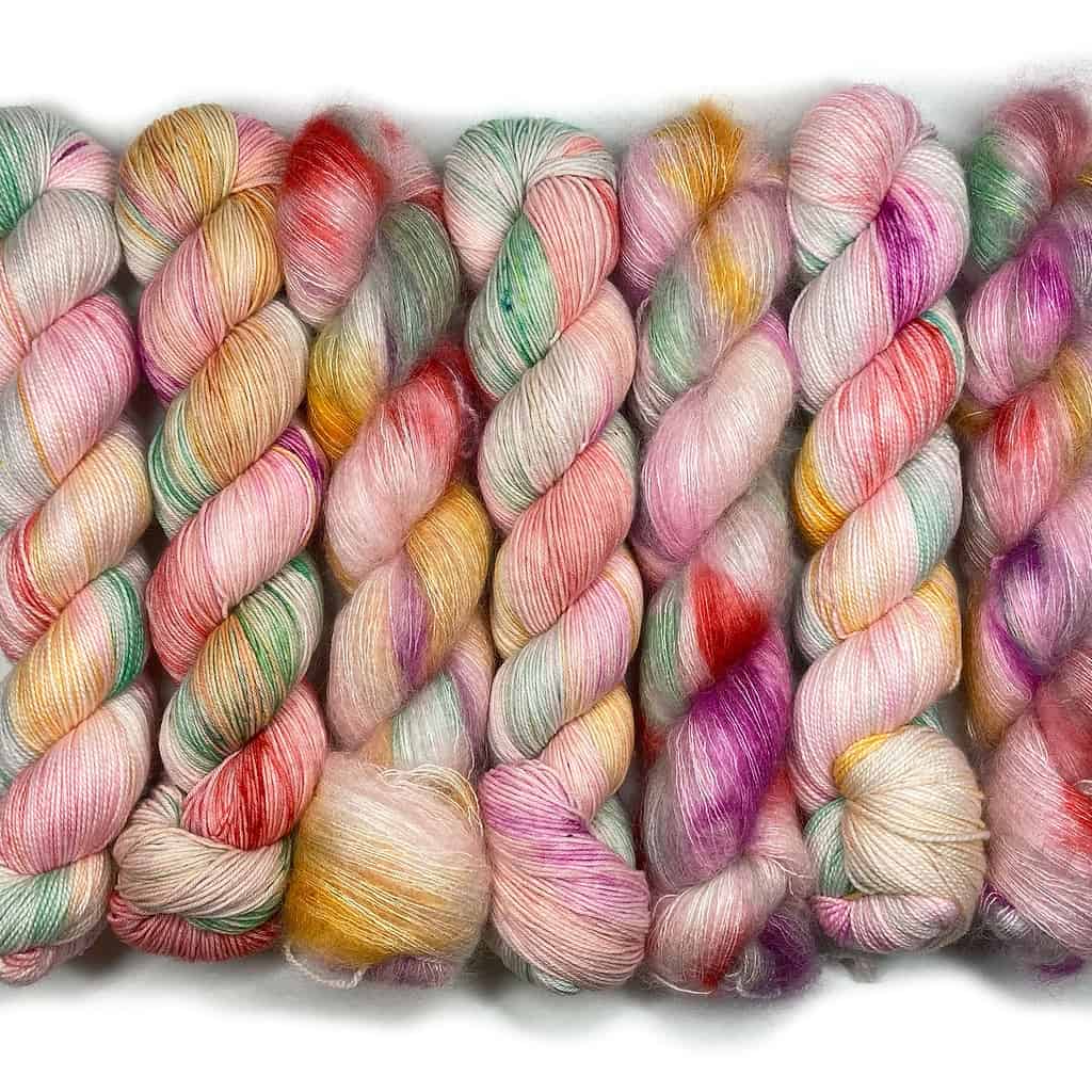 Light pink yarn with pops of red, yellow, green and purple.