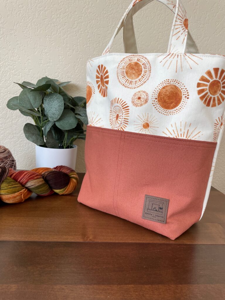 A mid sized project tote with golden sun print canvas with contrasting cinnamon canvas fabric.