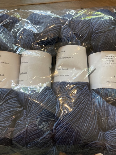 Skeins of gray yarn in a clear bag.