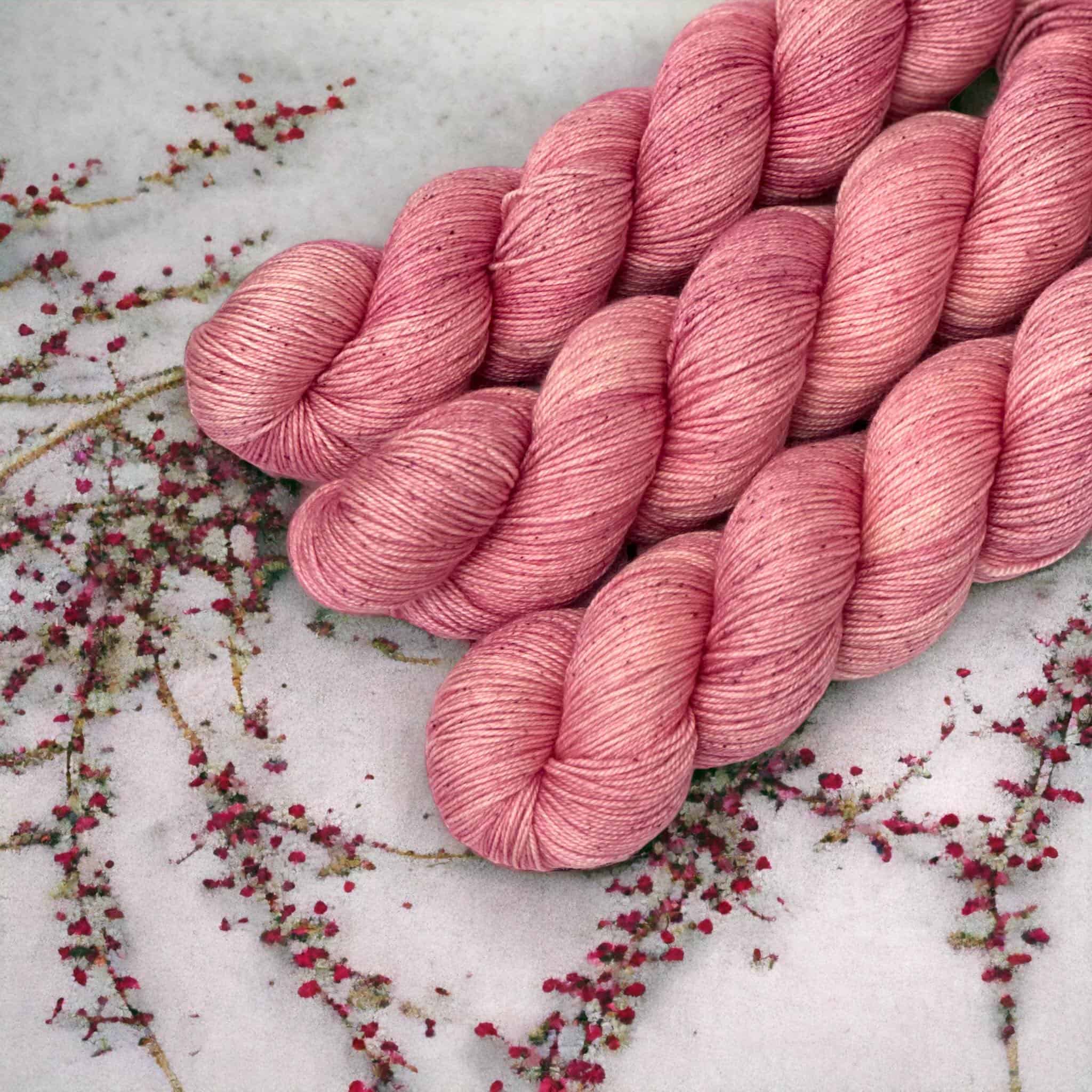 Three skeins of light pink yarn.