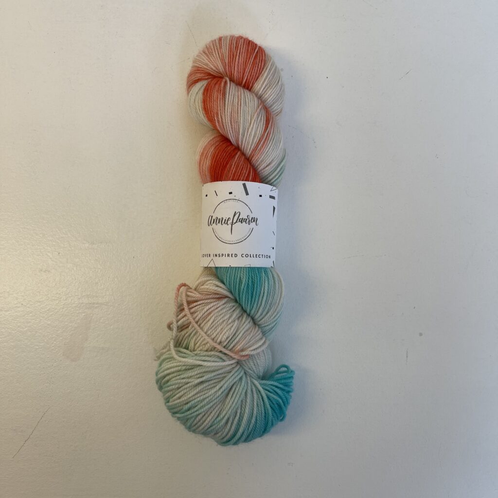 A skein of white, blue and pink variegated yarn.
