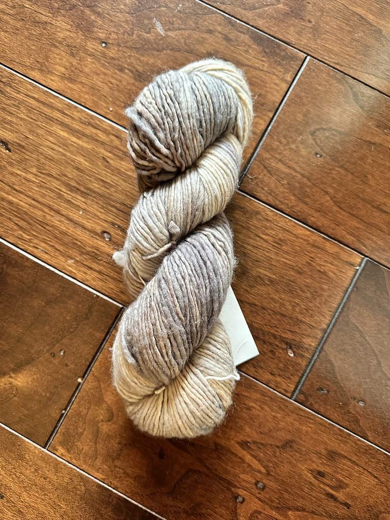 A skein of cream and brown worsted weight yarn.