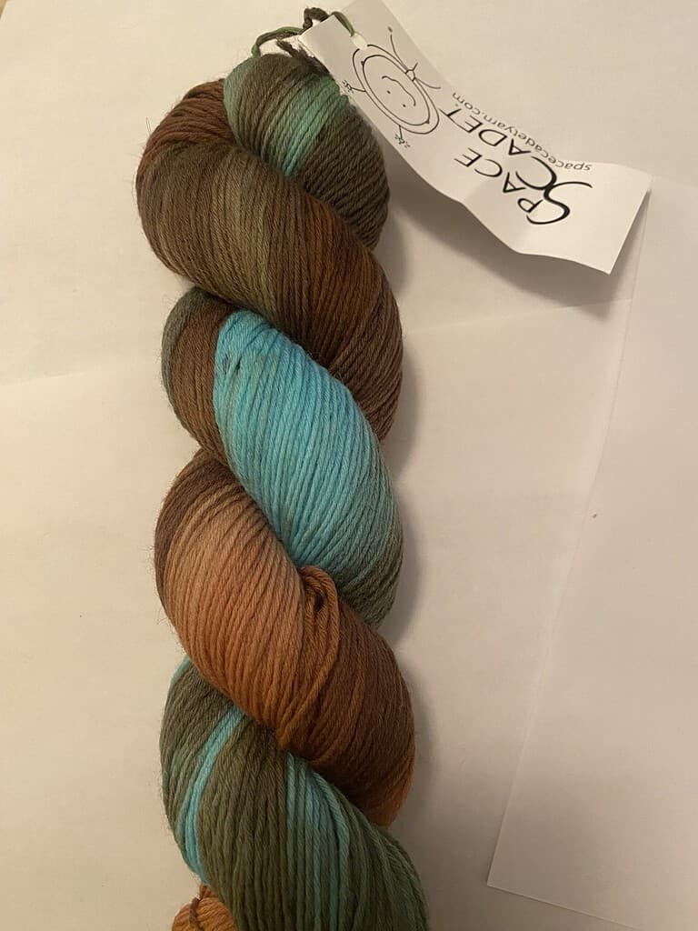 A skein of variegated aqua blue and brown yarn.